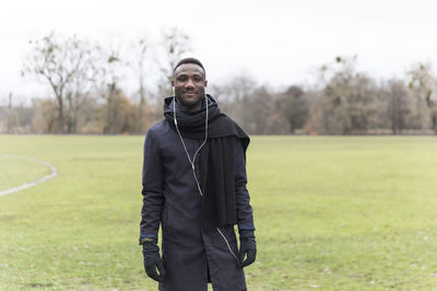 Portrait of smiling man standing on field