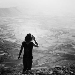 Rear view of woman on mountain on sunny day