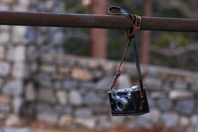 Close-up of camera hanging on rusty metal