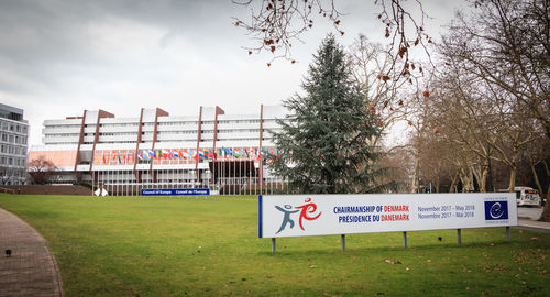 Information sign on field against sky