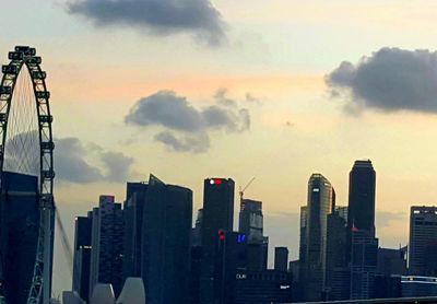 Modern buildings in city against cloudy sky