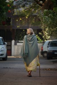 Rear view of senior woman walking on road