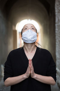 Portrait of woman wearing mask standing at home