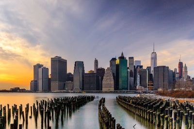 Panoramic view of sea and buildings against sky during sunset