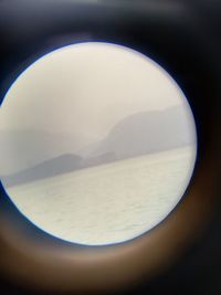 Close-up of sea against sky seen through window