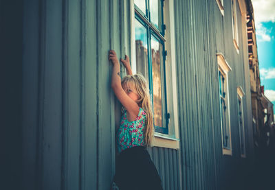 Girl standing by building