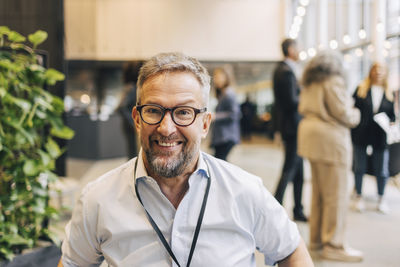 Portrait of smiling male entrepreneur wearing eyeglasses during seminar at convention center