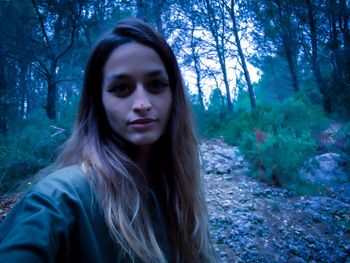 Portrait of beautiful young woman in forest