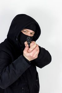 Portrait of man holding mask against white background