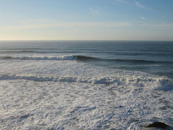 Scenic view of ocean waves crashing in the pacific on a sunny day.