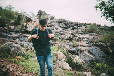 Full length of young man standing on rock