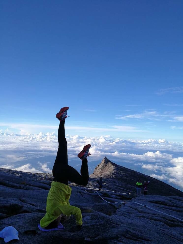 MAN WITH ARMS OUTSTRETCHED AGAINST MOUNTAINS