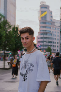 Portrait of young man standing against building