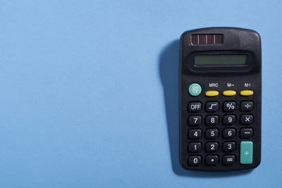 Close-up of calculator against blue background