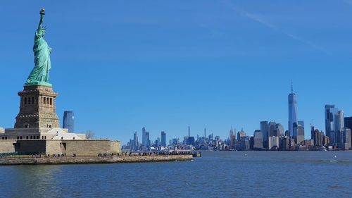 View of city at waterfront statue of liberty 