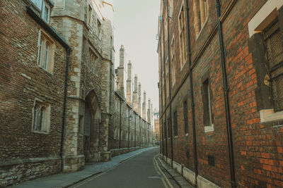 Narrow street amidst buildings against clear sky