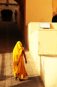 Rear view of woman walking on pavement at amber fort