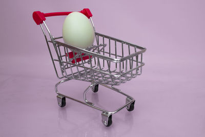 Side view of a metallic structure against pink background