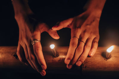 Close-up of hand holding lit candle