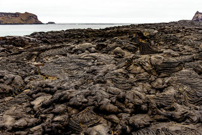 Scenic view of rocks on beach against sky