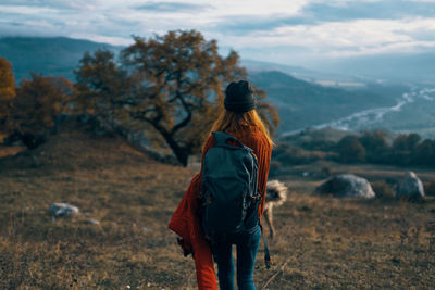 Rear view of man walking on field