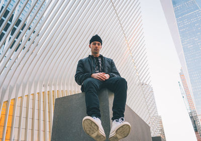 Full length of man sitting in city