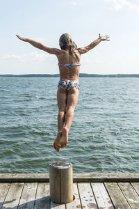 Woman jumping into sea