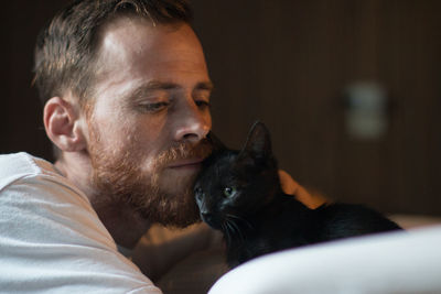 Close-up of man with cat at home