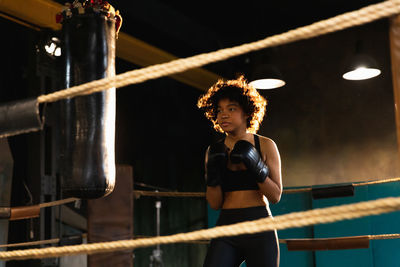 Full length of young woman exercising in gym