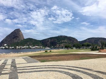 Scenic view of sea by mountains against sky