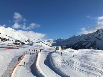 People skiing on snowcapped mountain against sky