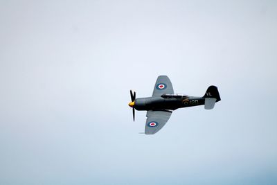 Low angle view of airplane flying against clear sky