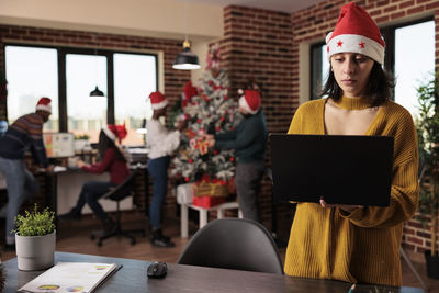 Friends using digital tablet while sitting in office