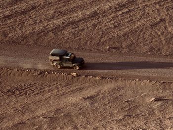 Car on a dirt road in desert field