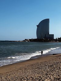 Scenic view of beach against clear blue sky