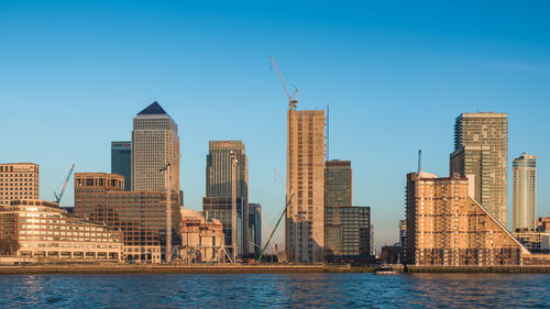 Low angle view of skyscrapers against clear blue sky