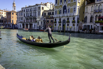 People in boat on canal in city