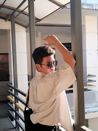 Side view of young man standing in factory