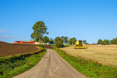 Rural landscape view with a combine harvester on a field