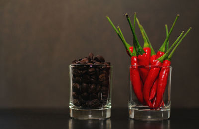 Close-up of red chili peppers in glass jar on table