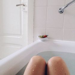 Midsection of woman bathing in bathtub