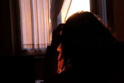Silhouette woman using mobile phone at home