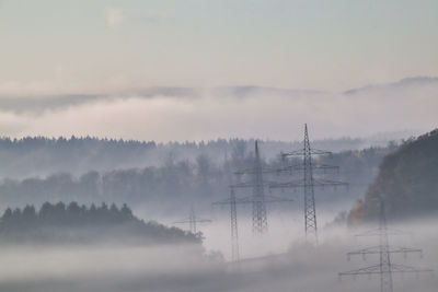 Scenic view of trees against sky during foggy weather