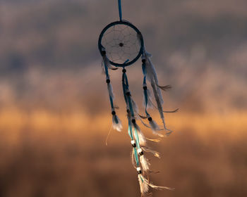 Close-up of dream catcher against sky at sunset