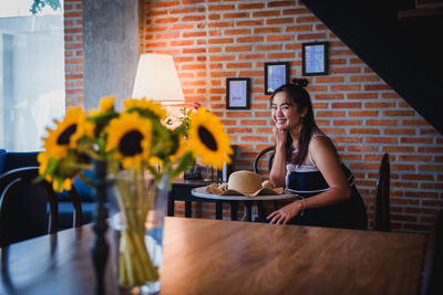 Young woman sitting on table at cafe