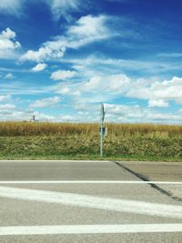 Empty road by landscape against sky