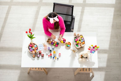 High angle view of woman using phone while sitting on table