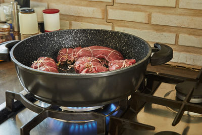 Chef fries meat rolls in a frying pan on a gas stove. french gourmet cuisine