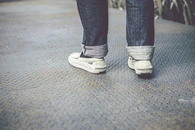 Low section of man standing on footpath