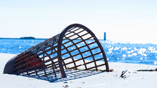 Close-up of deck chairs on beach against clear sky